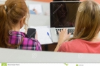 females-using-laptop-cellphone-lecture-hall-close-up-rear-view-two-college-35784453